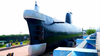 a large black submarine sitting on top of a sidewalk