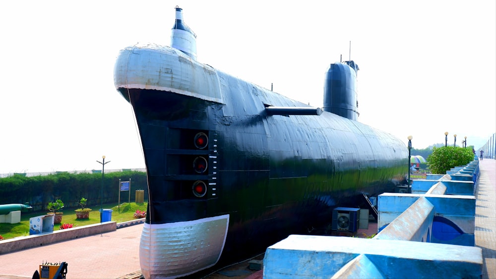 a large black submarine sitting on top of a sidewalk