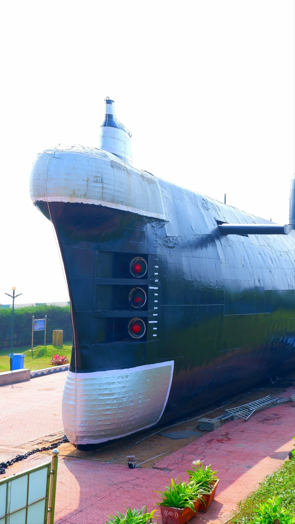 a large black submarine sitting on top of a lush green field