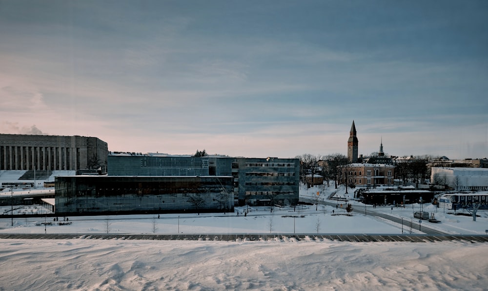 a view of a snowy city with a clock tower in the distance