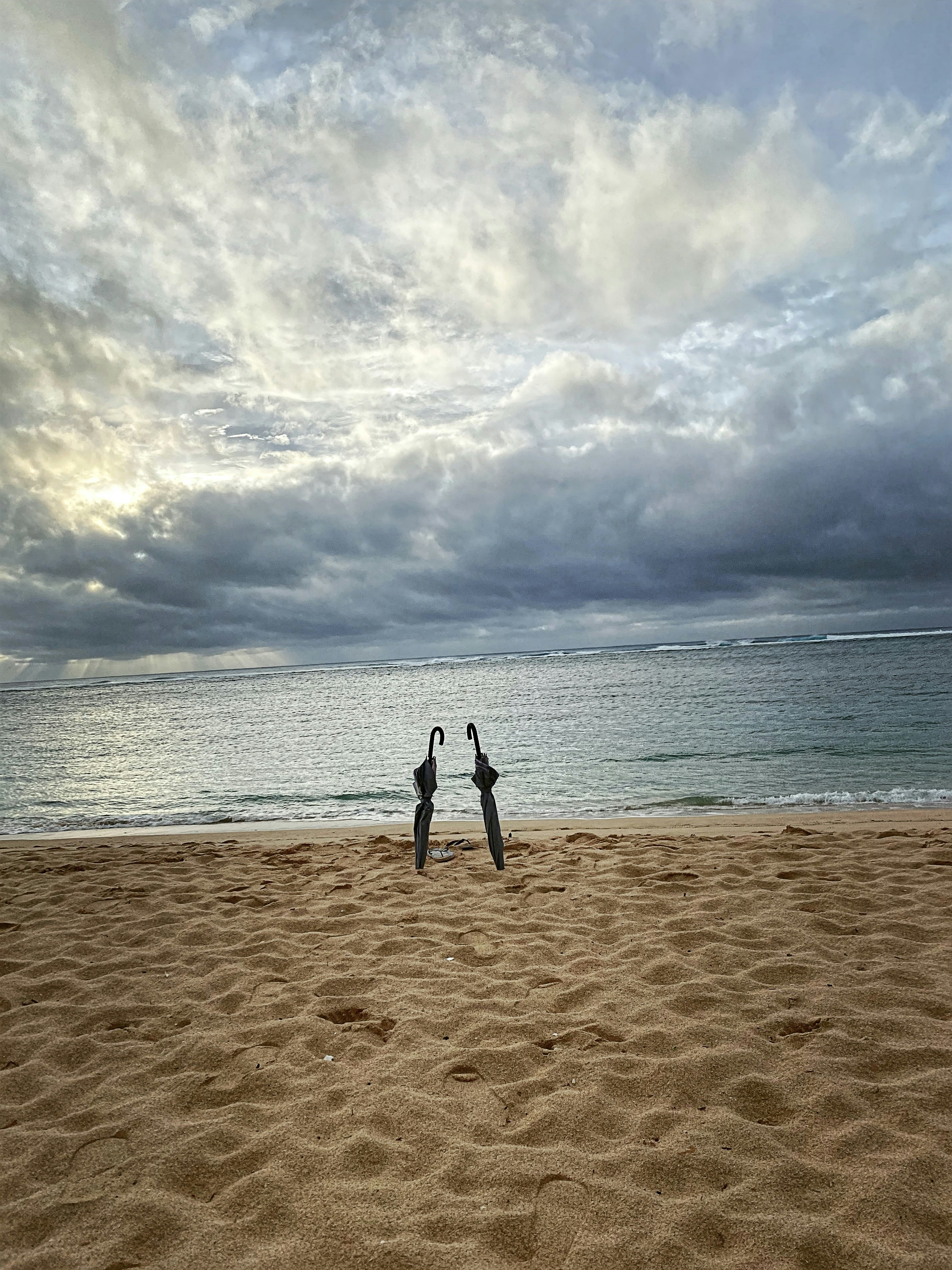 a couple of people standing on top of a sandy beach