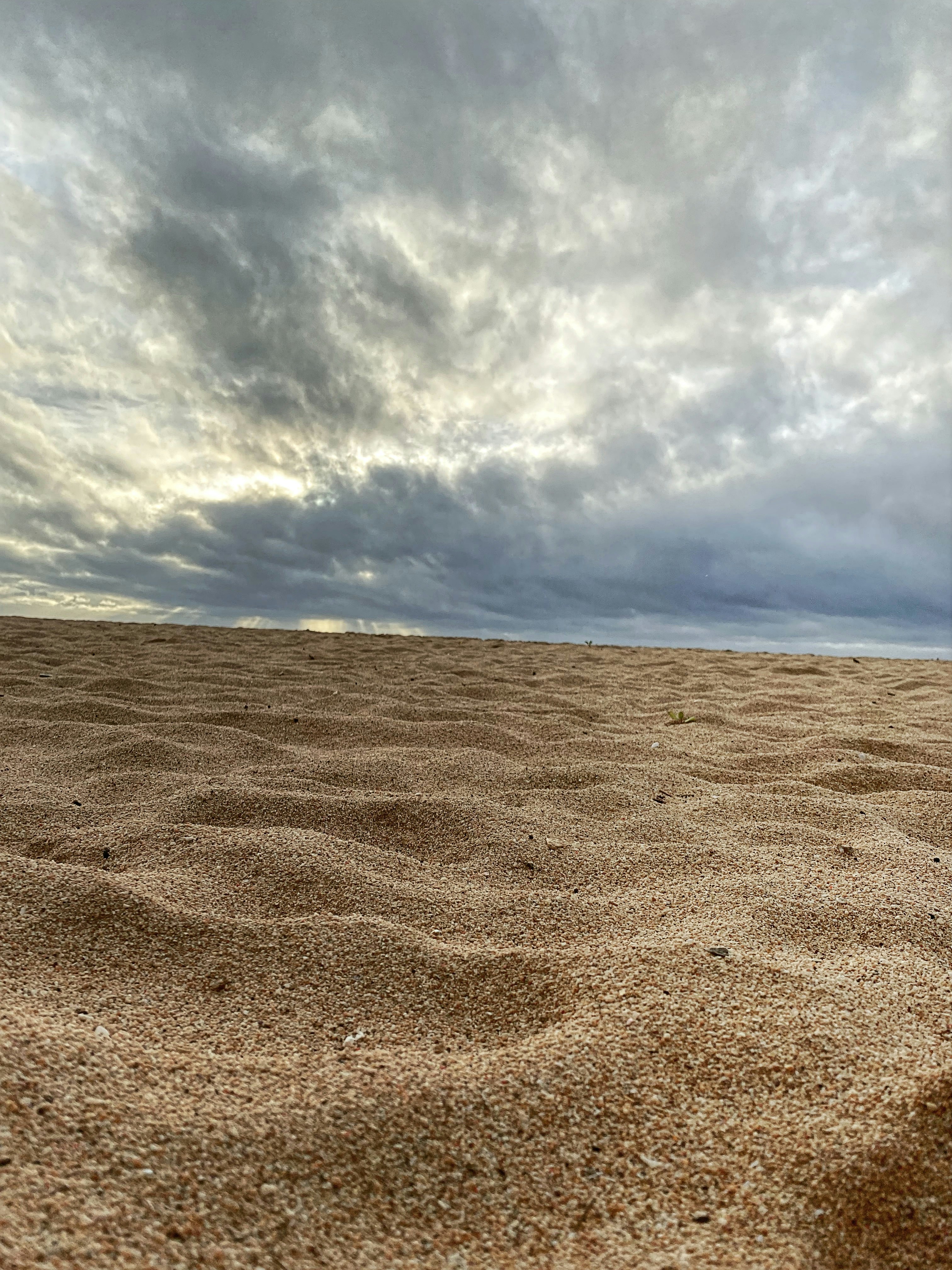 a sandy beach under a cloudy sky