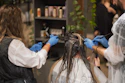 a woman getting her hair done by a hair stylist