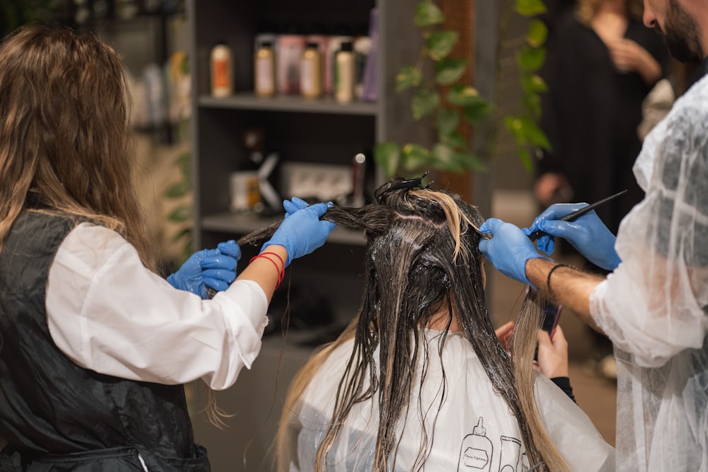 a woman getting her hair done by a hair stylist