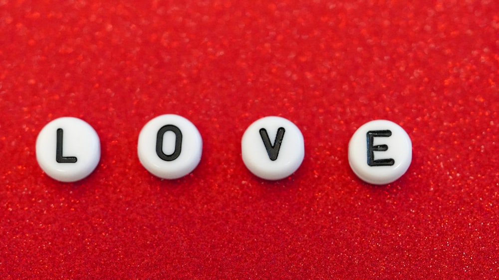 the word love spelled out in small letters on a red surface