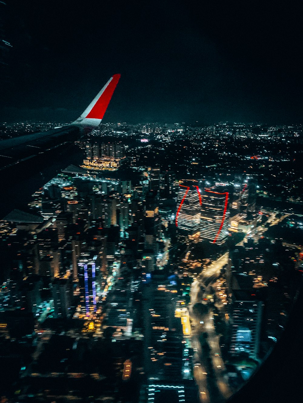 an airplane wing flying over a city at night