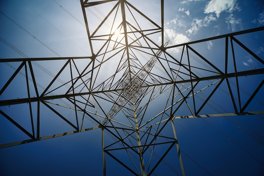 a high voltage power line with the sun shining behind it