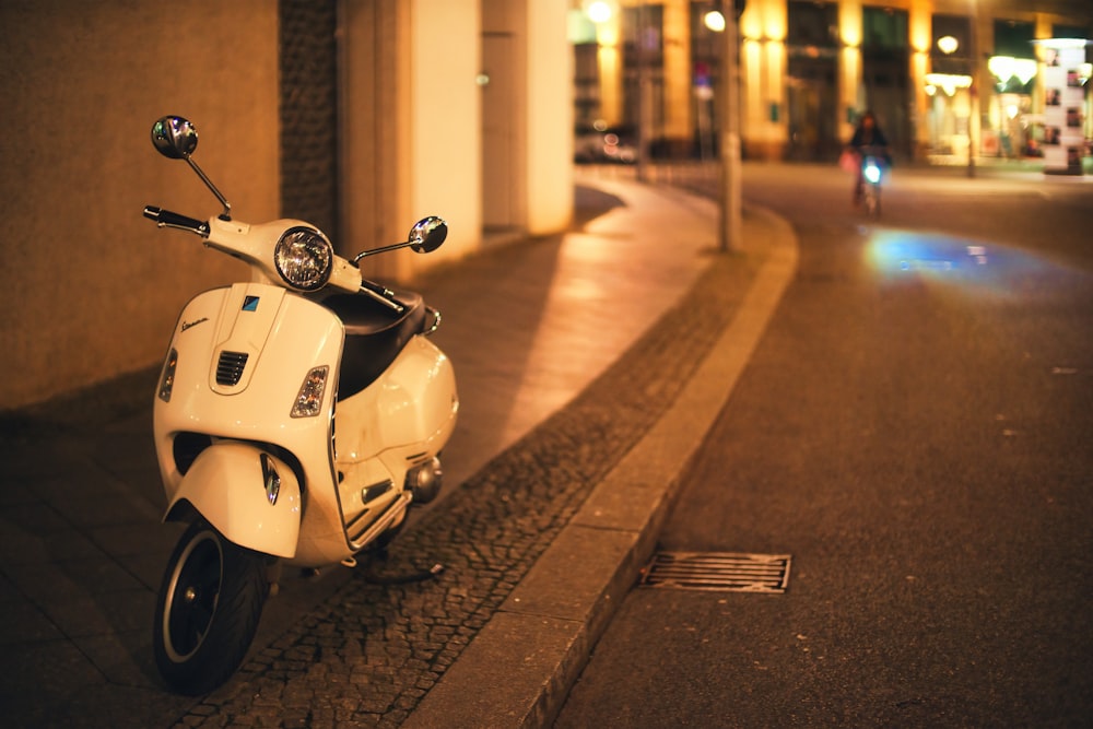 a white scooter parked on the side of a street