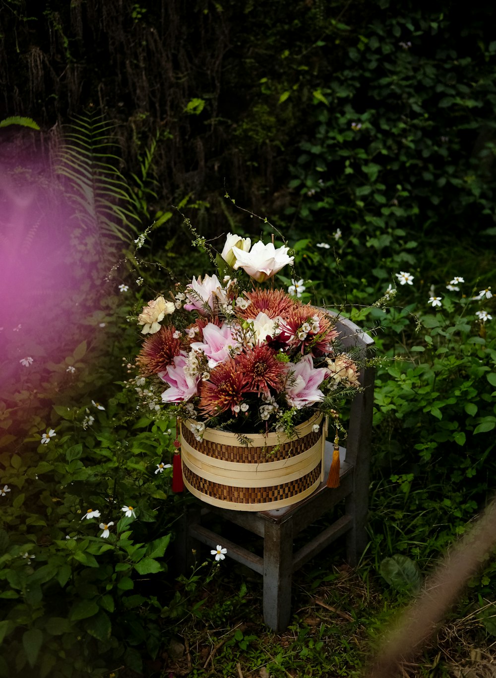 a basket of flowers sitting on a wooden bench