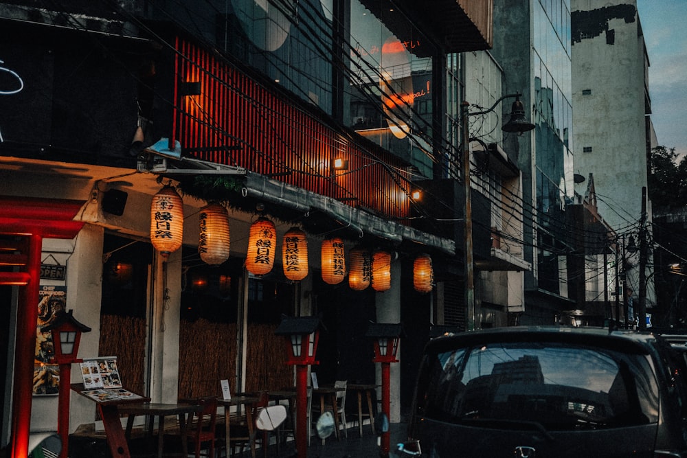 a black car parked in front of a restaurant