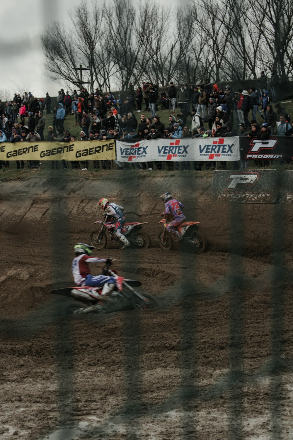 a group of people riding dirt bikes on top of a dirt field