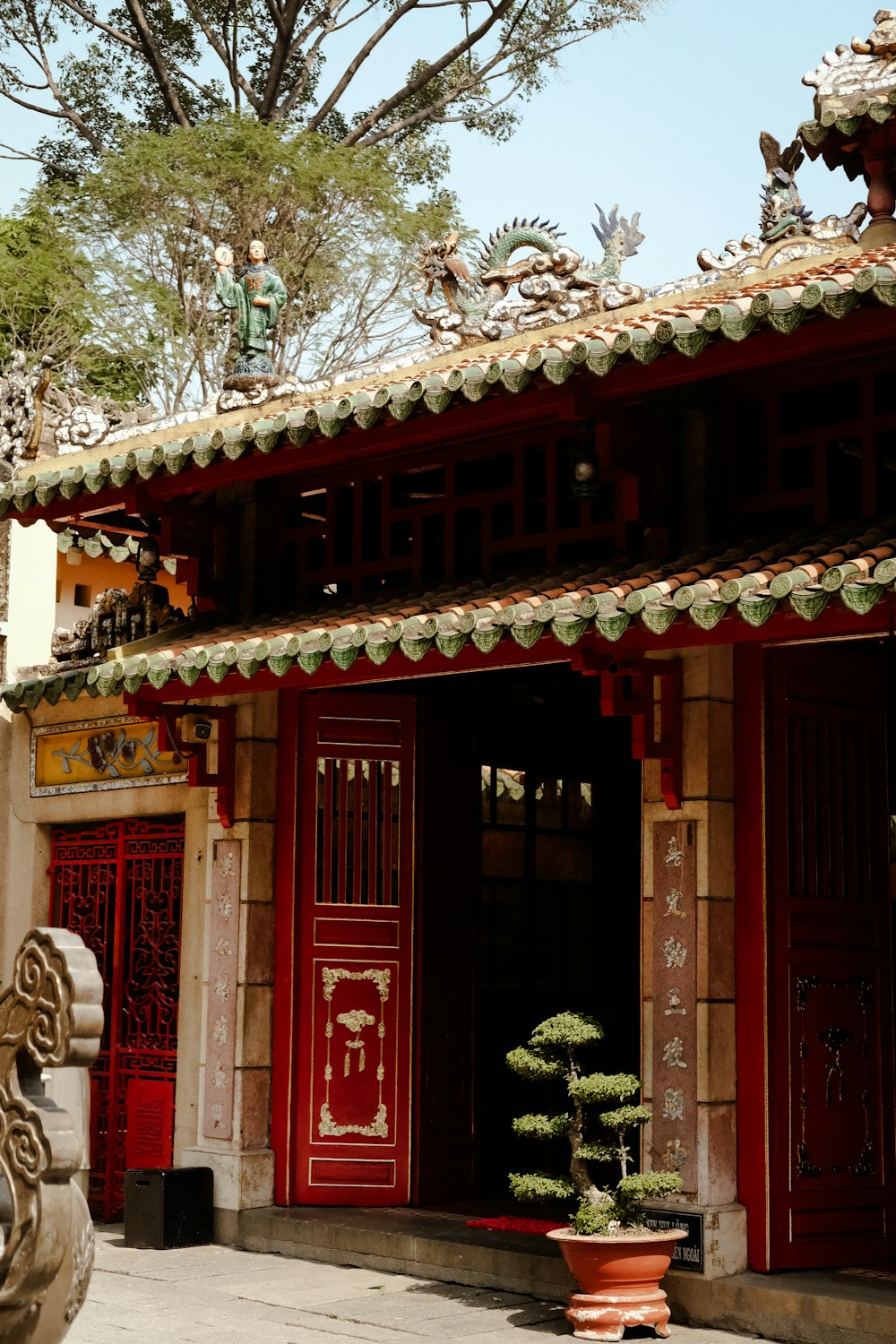 a building with a red door and a tree in front of it