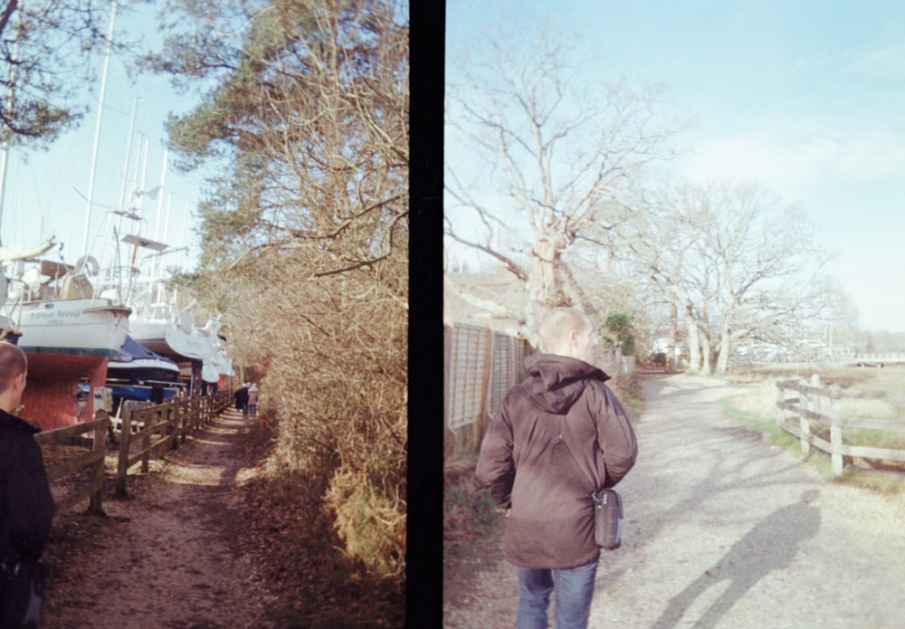 a man walking down a path next to a boat