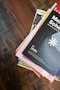 a stack of books sitting on top of a wooden table