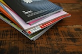 a stack of books sitting on top of a wooden table