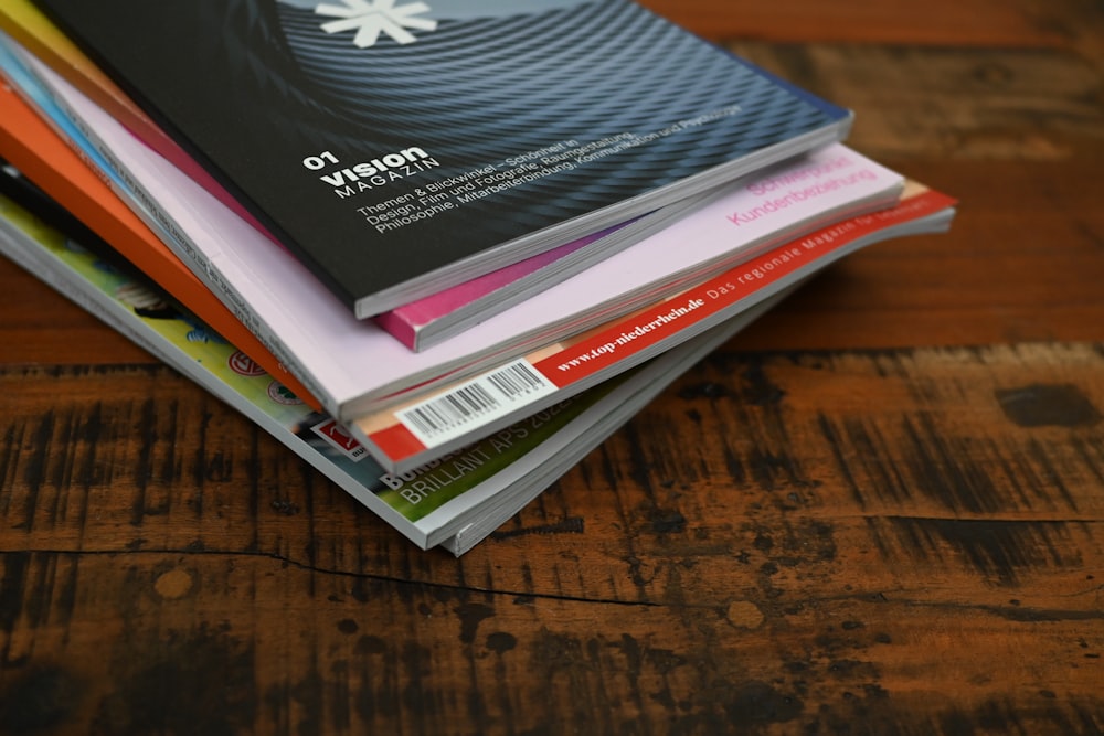 a stack of books sitting on top of a wooden table