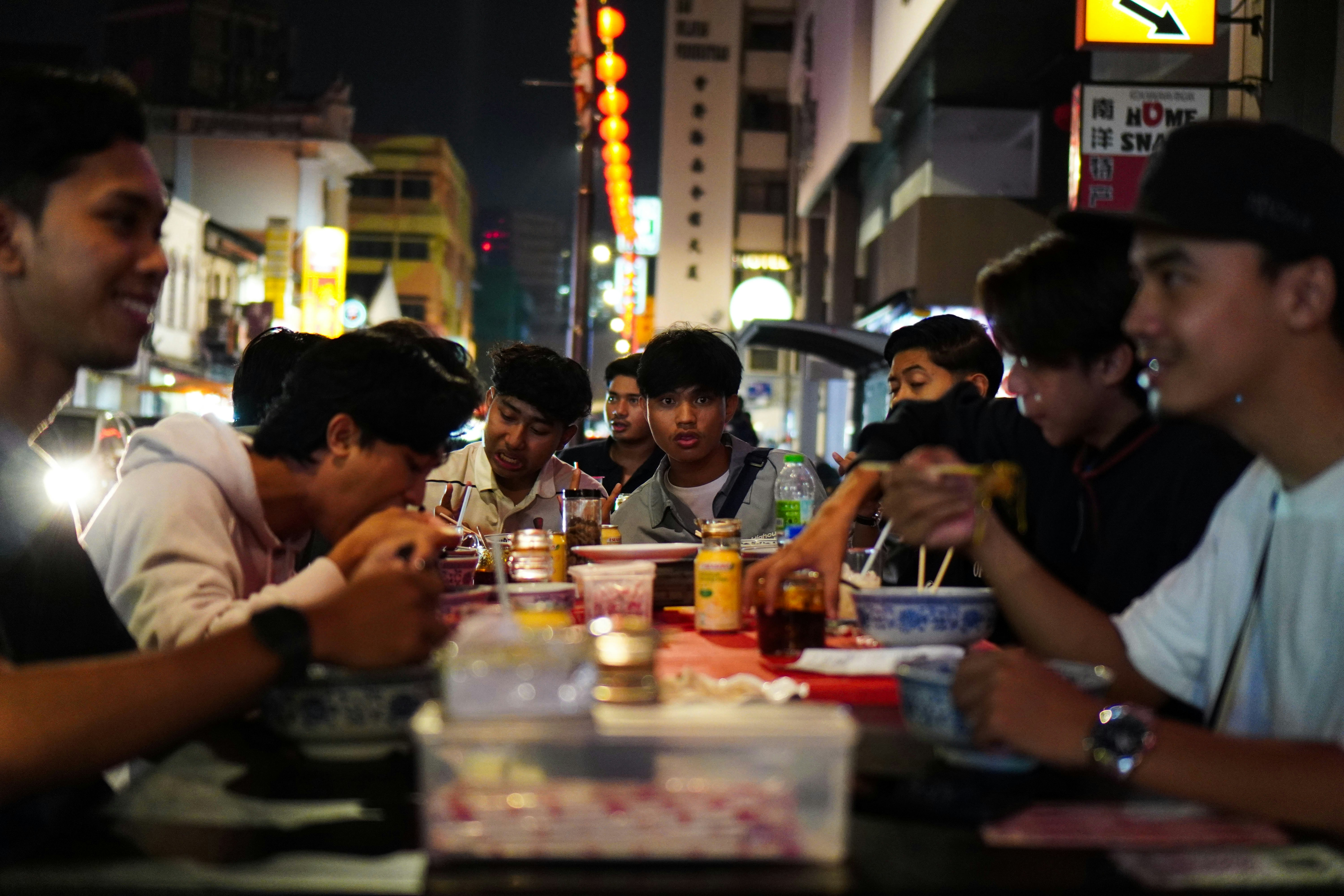 um grupo de pessoas sentadas à mesa comendo comida