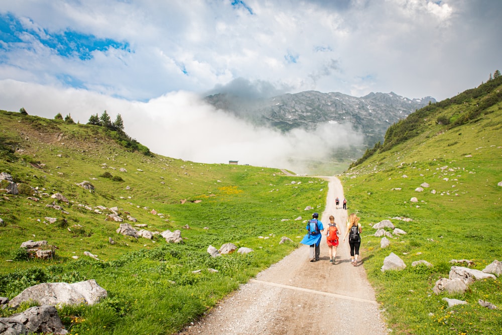 a group of people walking down a dirt road