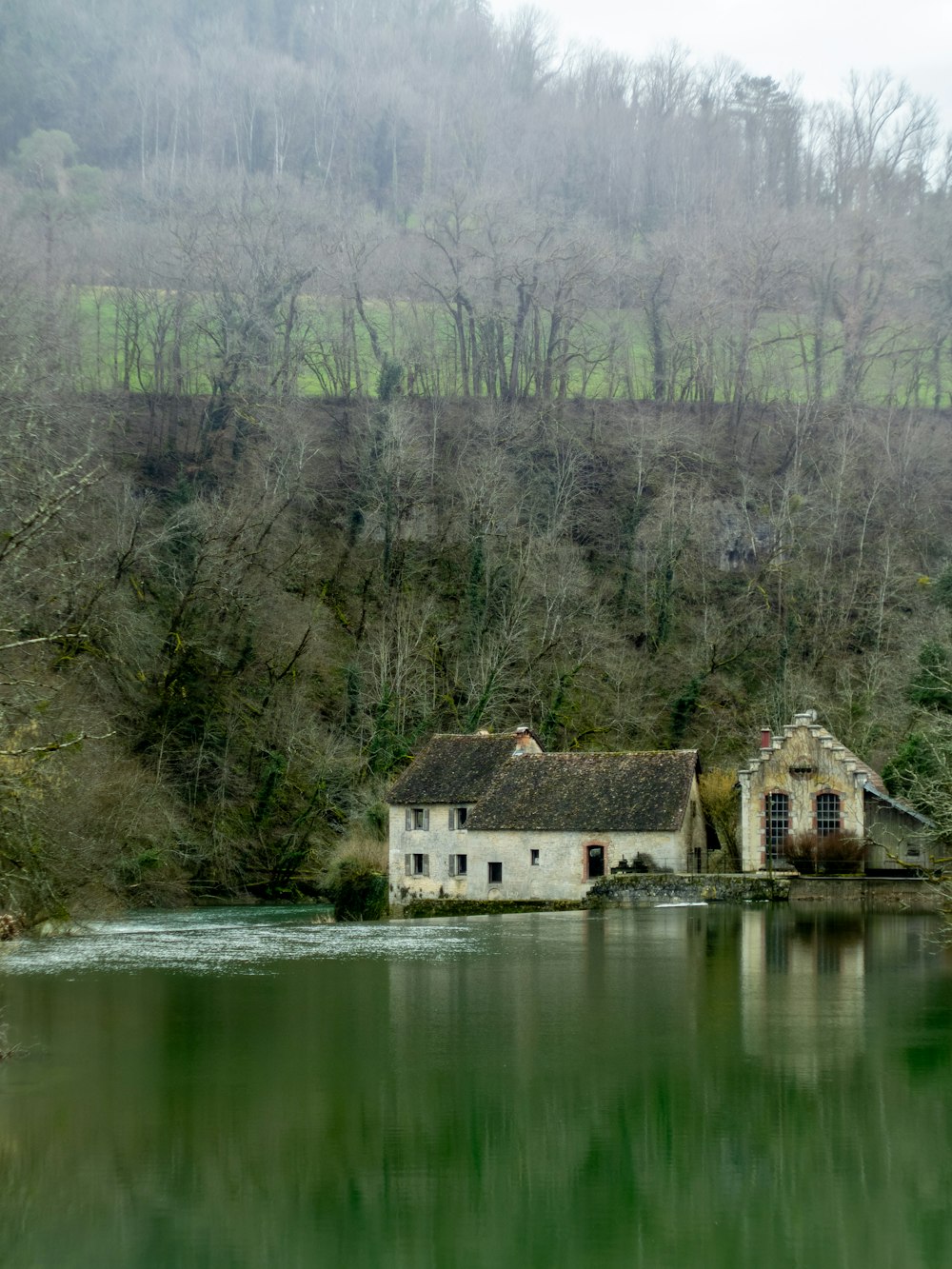 a house sitting on the shore of a lake