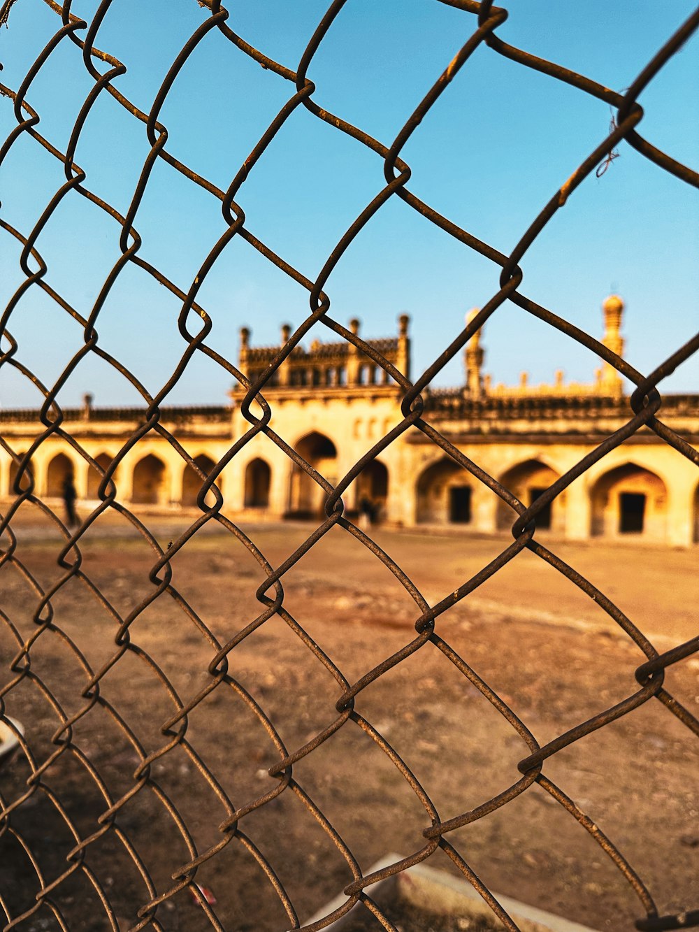 a large building behind a chain link fence
