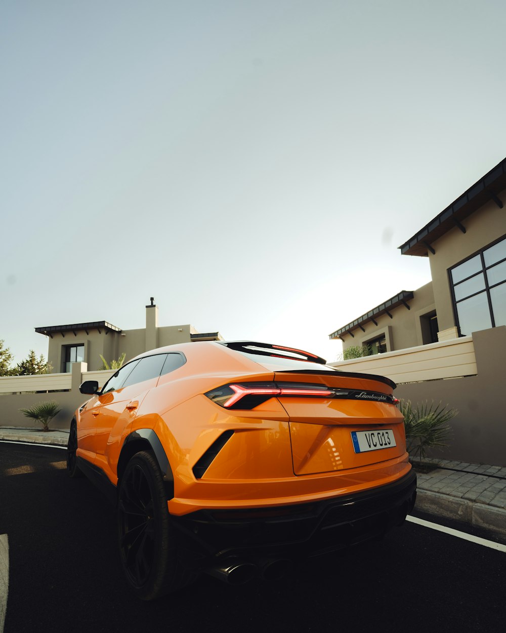Ein orangefarbener Sportwagen fährt eine Straße entlang