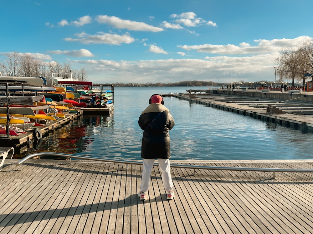 a person standing on a dock next to a body of water