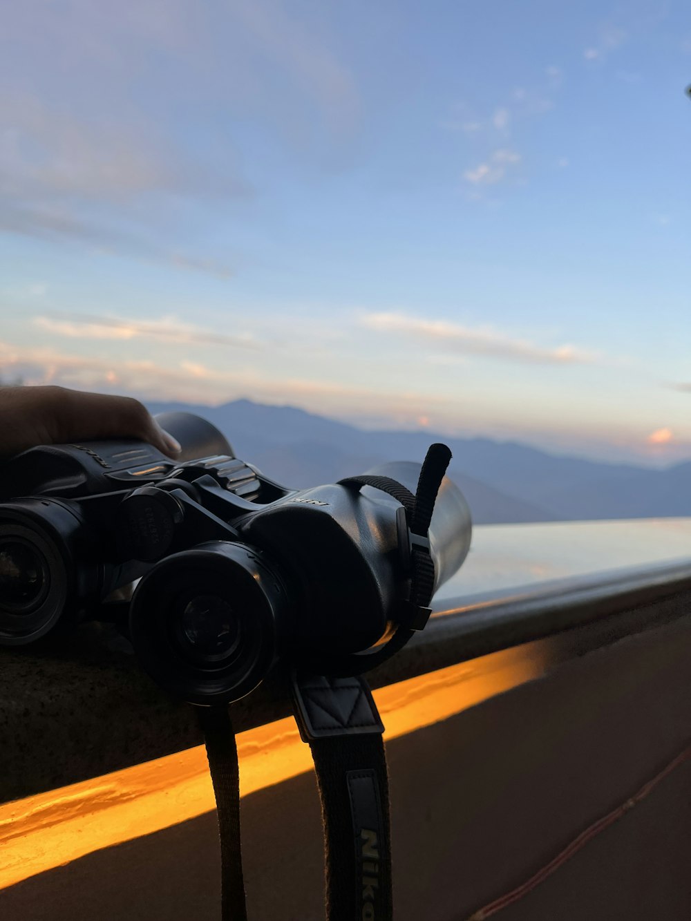 a person holding a camera on top of a ledge