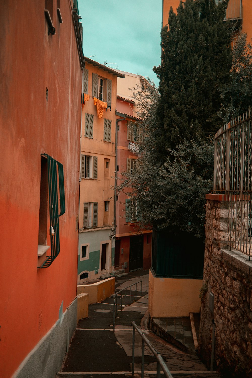 a narrow alley way with buildings and trees in the background