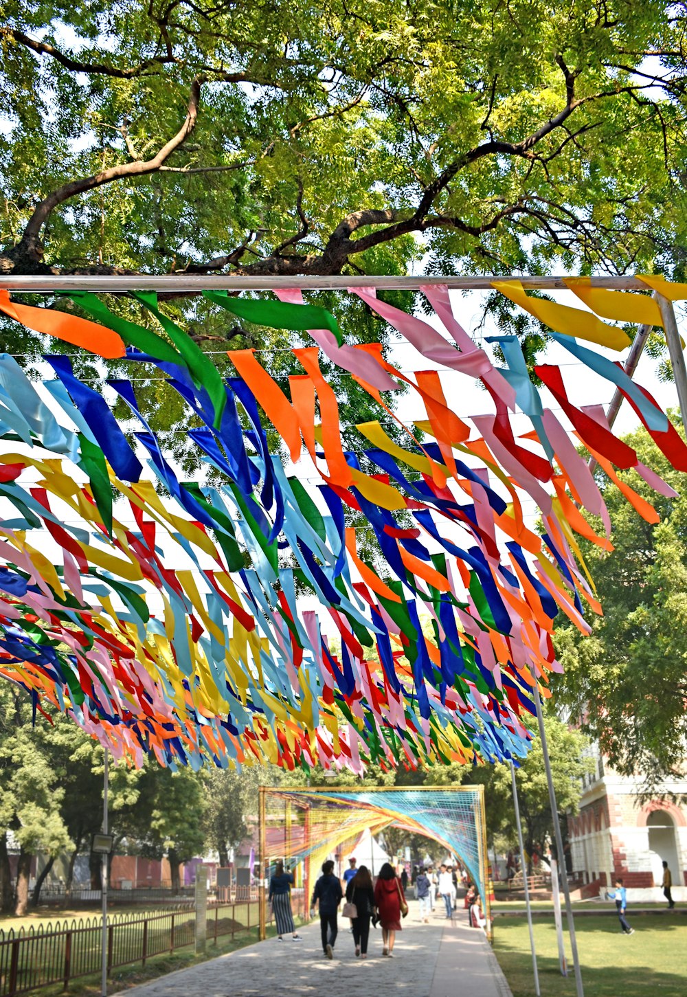 a group of people walking under a canopy of colorful streamers