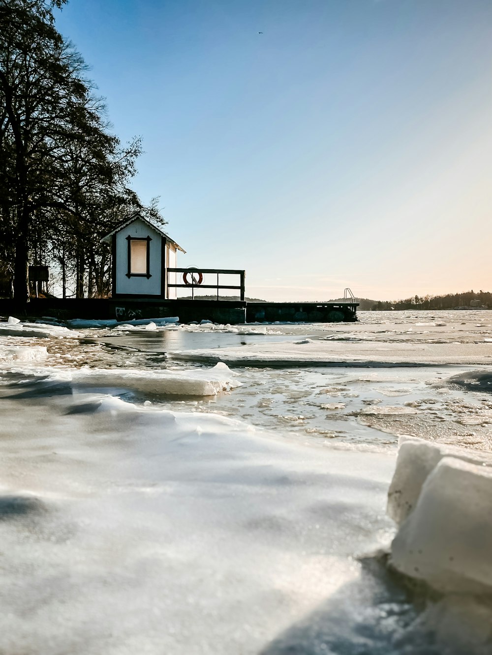 a house on the shore of a frozen lake