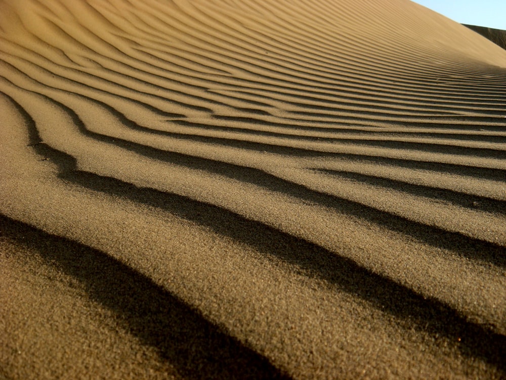 a sand dune with wavy lines in the sand