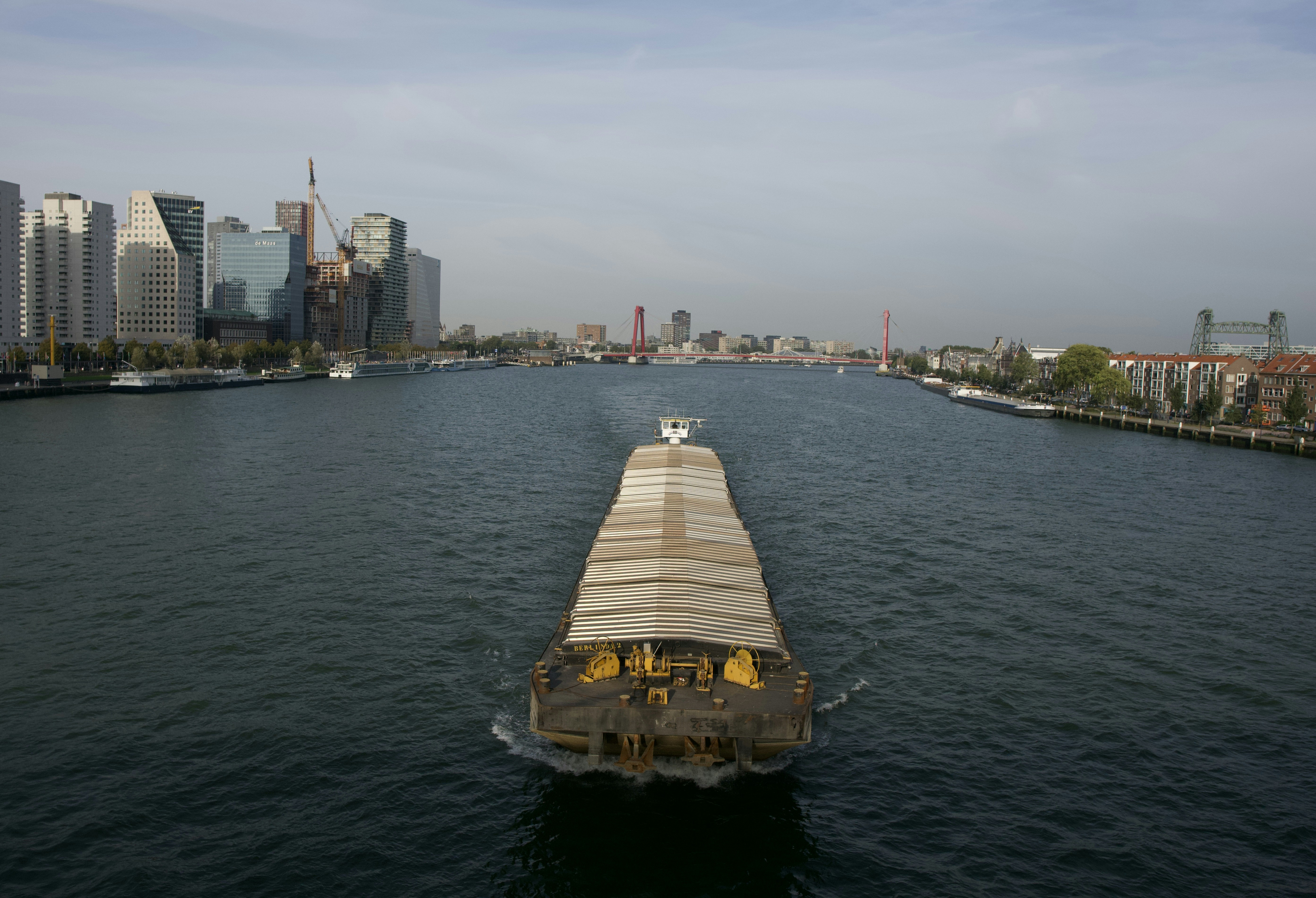 a boat traveling down a river next to tall buildings