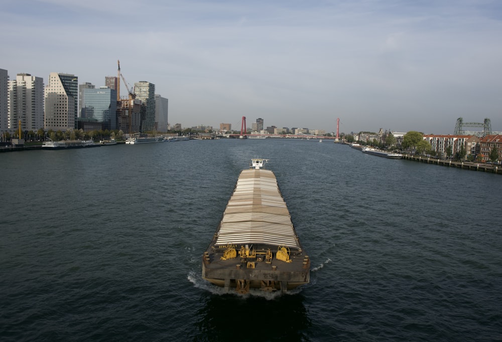 a boat traveling down a river next to tall buildings