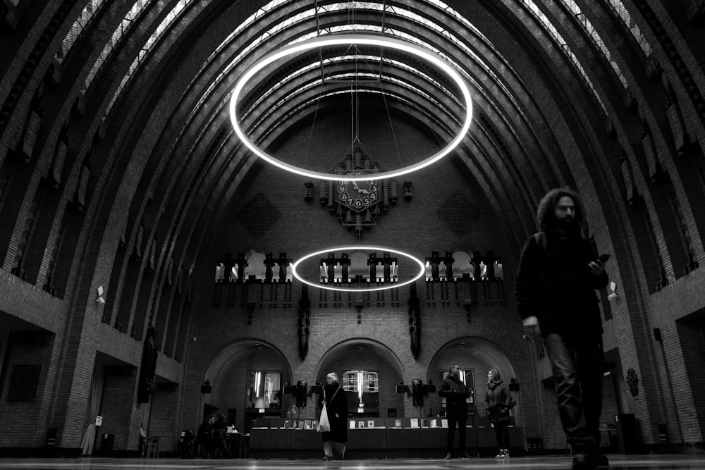 a person standing in a large building with a chandelier