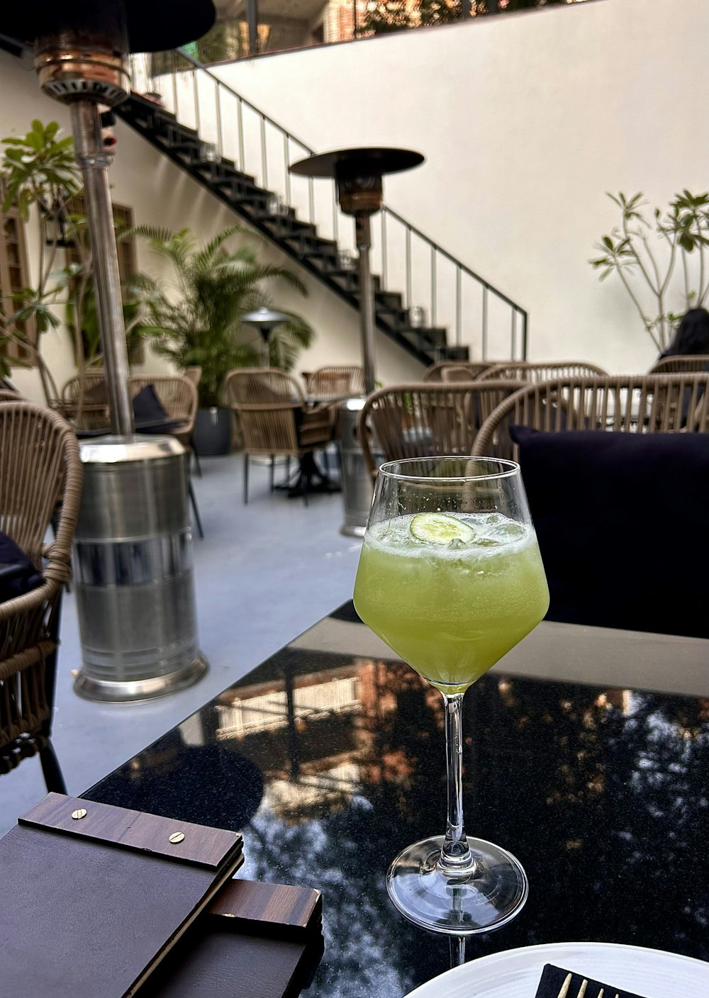 a glass of green liquid sitting on top of a table