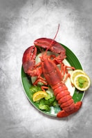 a plate of lobsters, lemons, and lettuce