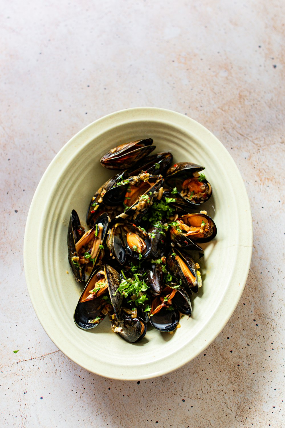 a white bowl filled with mussels on top of a table
