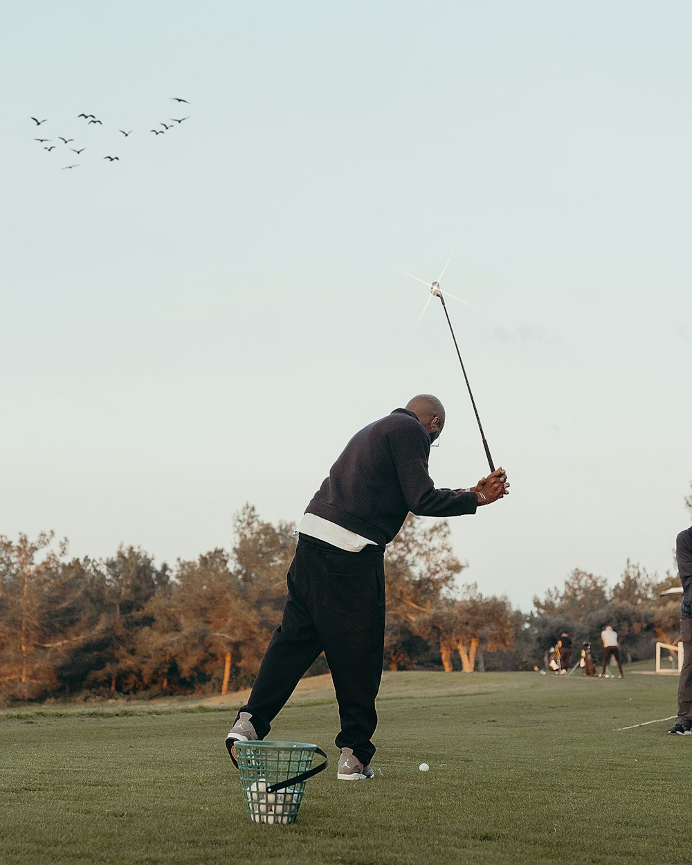 a man swinging a golf club on a golf course