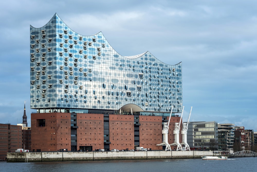 a large building with many windows next to a body of water