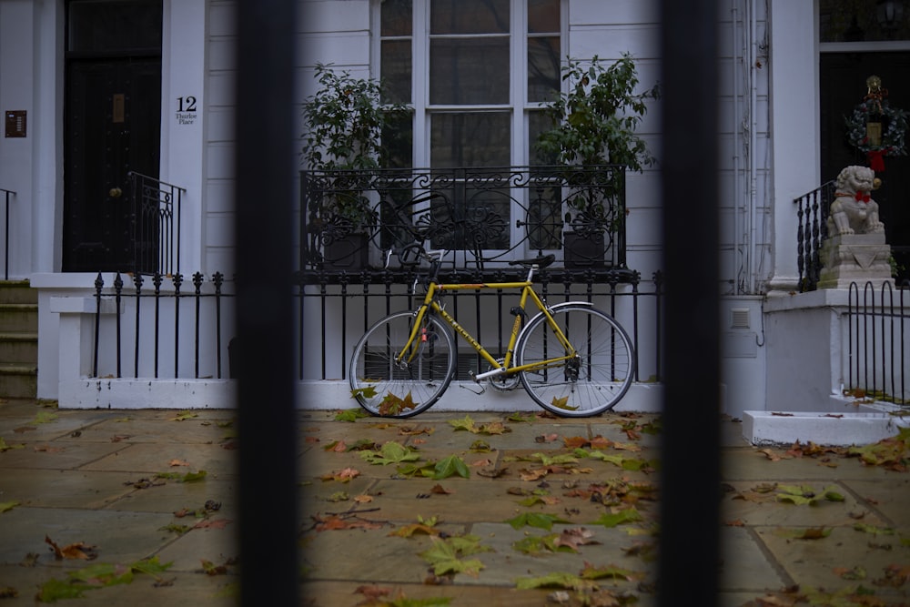 a yellow bicycle parked in front of a house