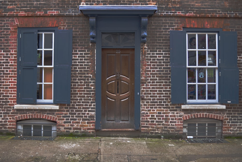 a brick building with blue shutters and a wooden door