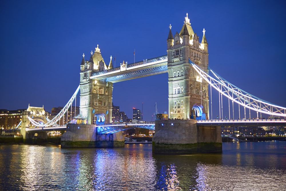 the tower bridge is lit up at night