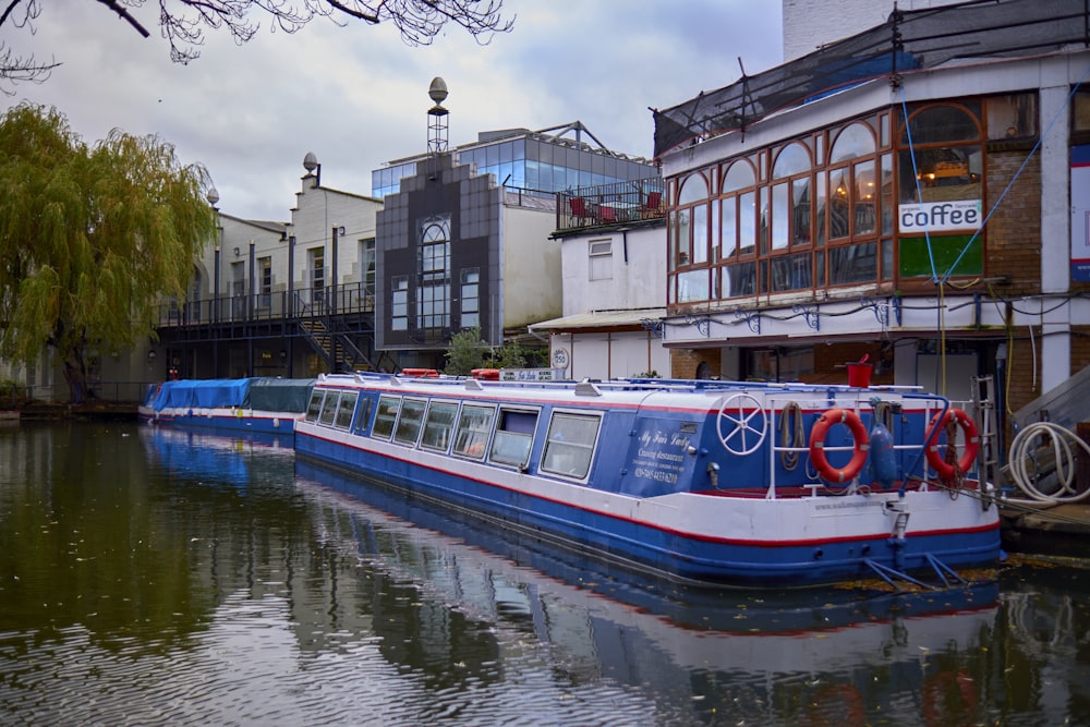 a blue and white boat floating on top of a river