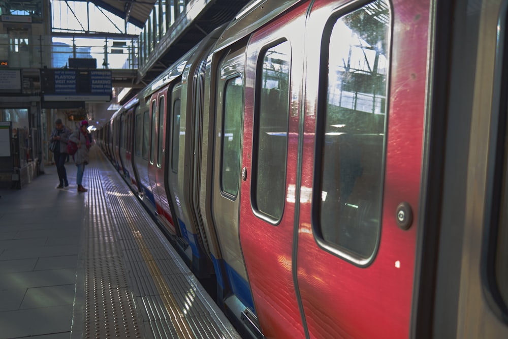 a red and silver train at a train station