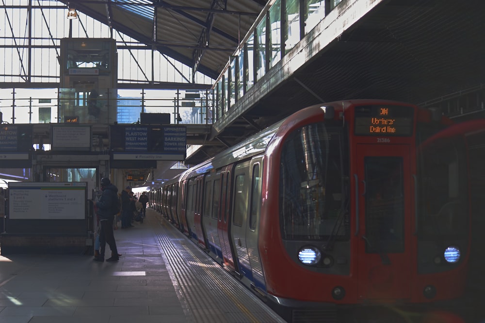 a red train pulling into a train station