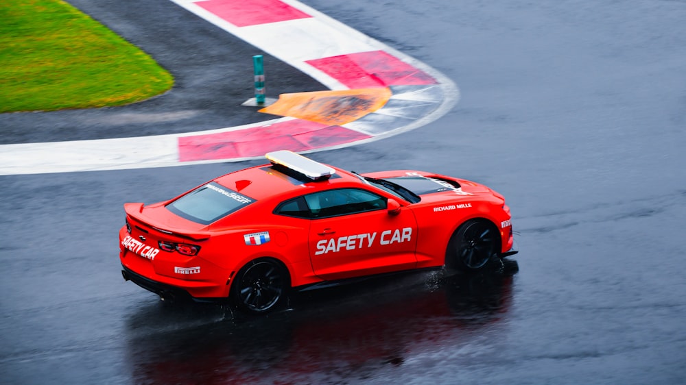 a red sports car driving on a wet track