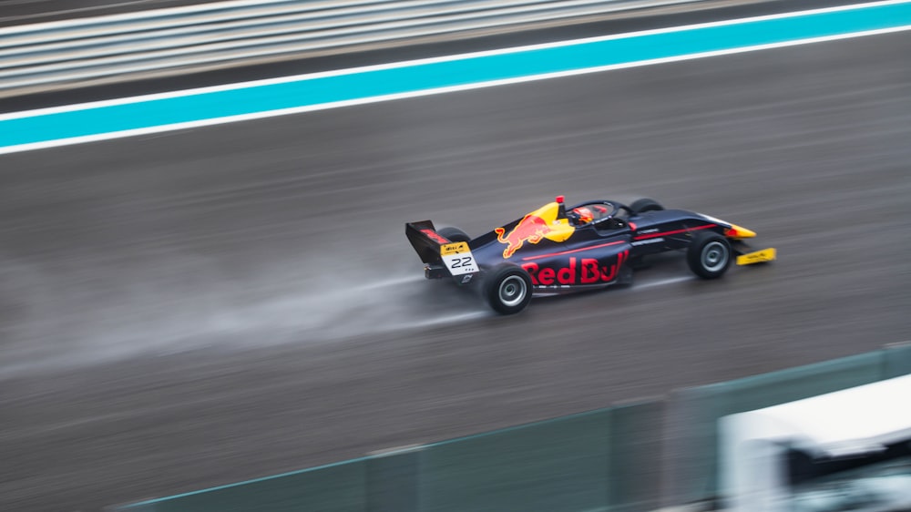 a red and yellow race car driving on a track