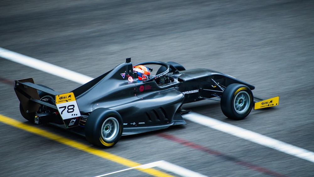 a black race car driving down a race track