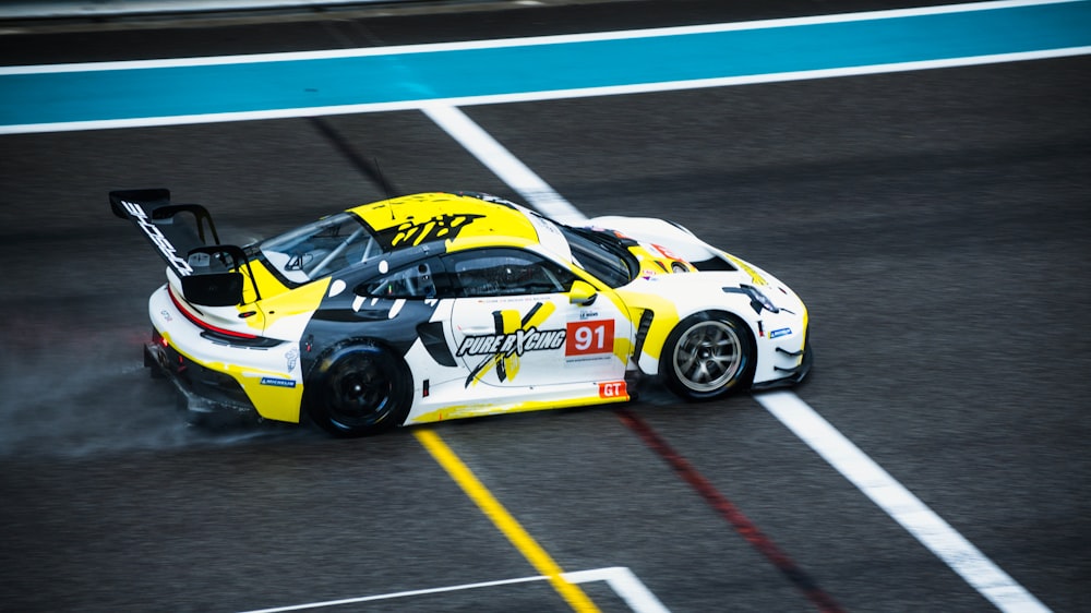 a yellow and white race car on a race track