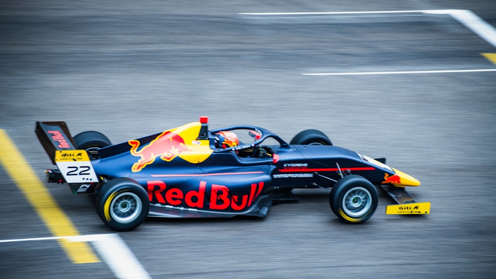 a red bull race car driving down a track